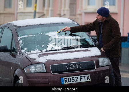 Pays de Galles Aberystwyth UK, Dimanche 10 Décembre 2017 Royaume-Uni : Météo Aberystwyth, sur la côte ouest de Galles, reçoit ses premières neiges de l'hiver, comme la propagation des conditions hivernales d'une grande partie de la moitié du Royaume-Uni. Un homme les couches de neige de son pare-brise de voiture le Met Office a publié des mises en garde à l'Ambre de neige importantes dans les Midlands et dans la majeure partie du pays de Galles, avec le risque de grave perturbation des déplacements Photo © Keith Morris / Alamy Live News Banque D'Images