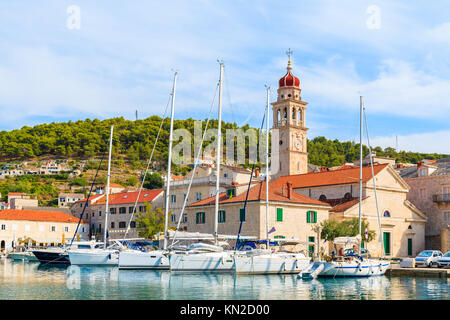 Location de bateaux dans Supetar port avec belle église sur l'île de Brac, la Dalmatie, Croatie Banque D'Images