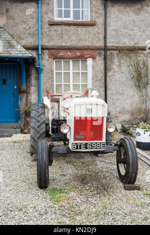 Vintage tracteur devant la maison de jardin en Cumbria, Angleterre, Royaume-Uni Banque D'Images