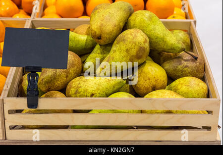 Variétés de poires conférence dans une boîte en bois avec une étiquette de prix Banque D'Images