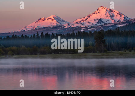 Le haut de la Montagne trois Sœurs deviennent roses au lever du soleil Vue du lac à Black Butte Ranch, gros plan, horizontal Banque D'Images