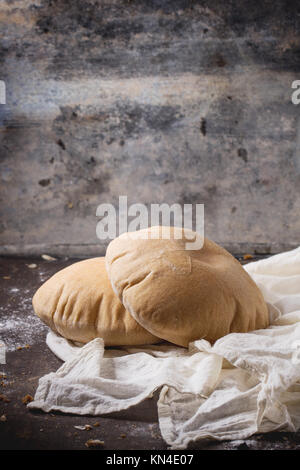 Deux de farine de pain de pita sur textile blanc, servi avec de la farine sur la table sombre Banque D'Images