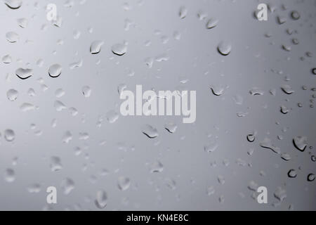 Grosses gouttes d'eau sur un fond de verre transparent. Banque D'Images