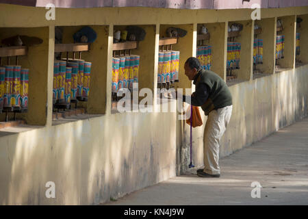 Vieil homme fait tourner les roues de prière tibétain au monastère de Mcleod Ganj, Inde Banque D'Images
