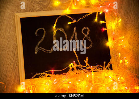 Lumières de Noël lumineux colorés et 2018 texte sur petit tableau noir - Nouveau concept de l'année Banque D'Images
