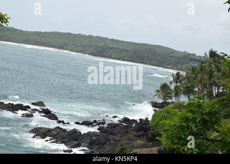 Vue mer et montagne. Océan et montagne. Rocky sur la mer avec des cocotiers à côté. Mer, entouré de verdure et de montagnes. Banque D'Images