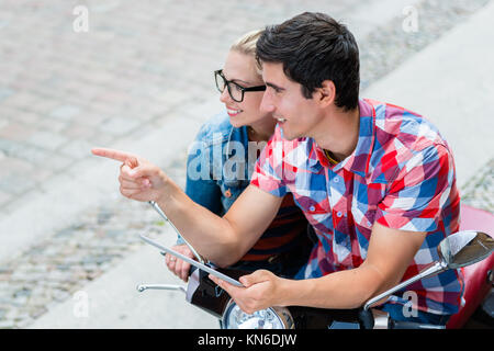 Couple sur la planification de voyage ville leur Vespa tour using tablet PC Banque D'Images