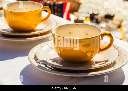 Tasse à pois jaune sur nappe blanche à Tablewear Cafe boire Banque D'Images