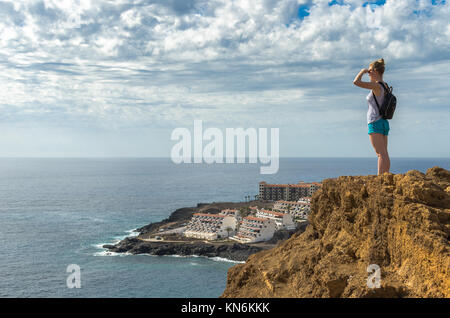 Jeune femme sur une falaise à l'ensemble de l'océan Atlantique et station balnéaire de Costa Del Silencion à Tenerife, Îles Canaries, Espagne Banque D'Images