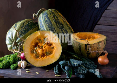 La citrouille et les graines de citrouille (Cucurbita pepo), et le chou kale se trouve sur la table de cuisine. Banque D'Images