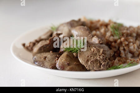 Foie de poulet compote et gruau de sarrasin sur une nappe blanche, en rétro tonifiant. Banque D'Images