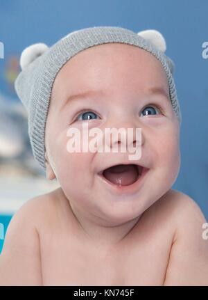 Portrait d'un bébé de quatre mois en souriant. Il est face vers le bas.