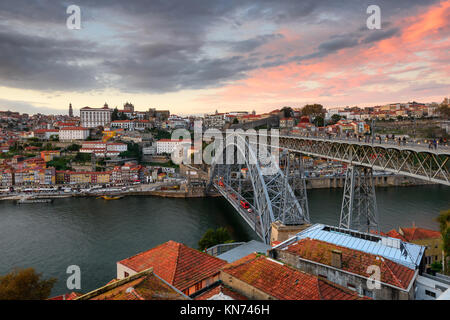 Porto, Portugal cityscape sur le fleuve Douro et Le Pont Dom Luis I au coucher du soleil. Paysage urbain au coucher du soleil avec les bateaux traditionnels. Banque D'Images