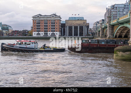 Riverside Cory tug boat redoute, sur la Tamise à Southwark, remorquage d'un chaland chargé de compacter des déchets provenant d'la ville de Londres. Banque D'Images