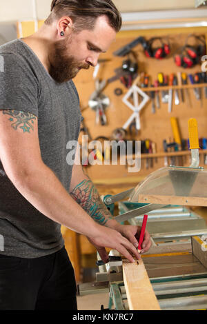 Carpenter mesurer la longueur d'une planche en bois avant de sciage à façon Banque D'Images