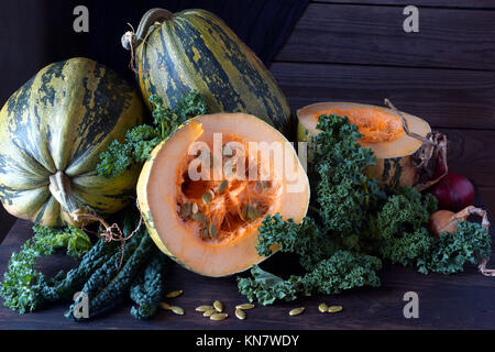 La citrouille et les graines de citrouille (Cucurbita pepo), et le chou kale se trouve sur la table de cuisine. Banque D'Images