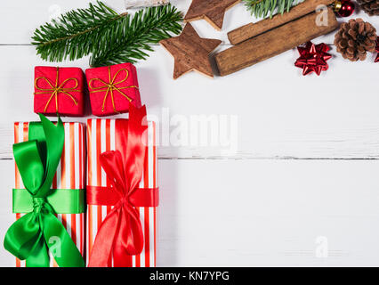 Giftwrapped présente et ornements de Noël sur la table en bois blanc Banque D'Images