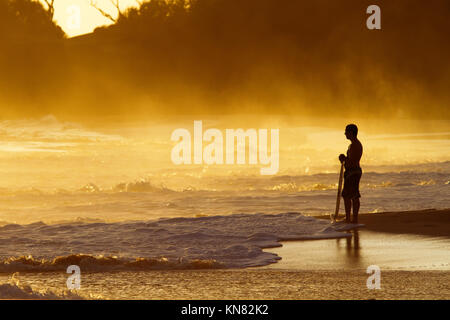 Skimboarder au coucher du soleil à Makena, Maui, Hawaii. Banque D'Images