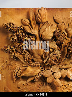 Ce relief floral de nature morte affiche un savoir-faire complexe, représentant des formes naturelles et des fleurs dans une tradition d'art décoratif et botanique. Banque D'Images