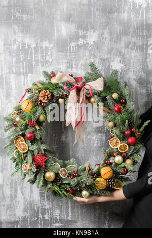 Belle couronne de Noël en femme mains. Préparation pour les vacances concept. Boutique de fleurs est un chef-d'œuvre d'un fleuriste Banque D'Images