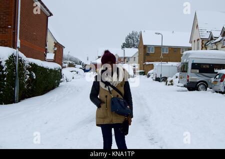 Femme dans une rue couverte de neige après les fortes chutes de neige à Hemel Hempstead, Royaume-Uni Banque D'Images