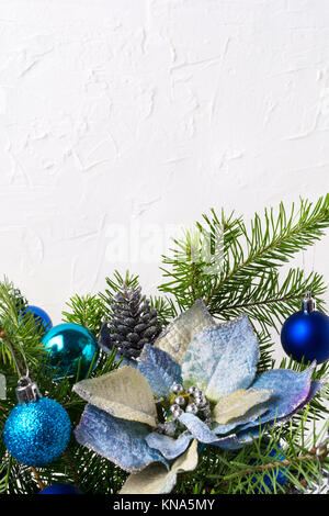 Noël arrière-plan avec les poinsettias en soie bleu, perles en argent, boules et branches, copy space Banque D'Images