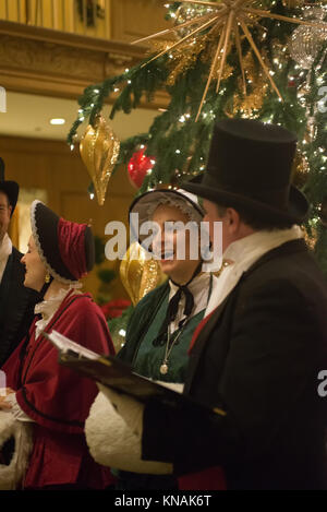 Groupe de personnes en costumes traditionnels chanter des chants de Noël à l'hôtel Fairmont Olympic Hotel à Seattle, Washington Banque D'Images