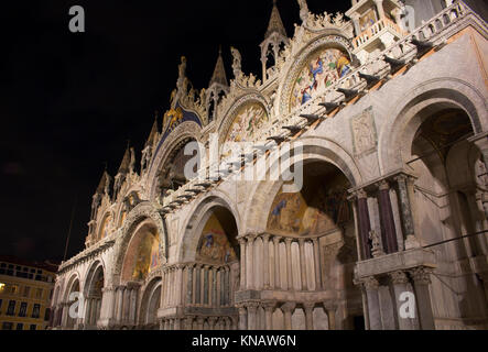 Vue sur la façade de la Basilique Saint Marc (San Marco) la nuit à Venise / Italie. La cathédrale emblématique avec un vaste espace intérieur doré, une multitude de mosaïques et un sur Banque D'Images