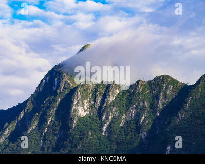 Le sommet de la haute montagne couverte avec belle brume et ciel nuageux ciel bleu. Pleine de calcaire et les falaises. Banque D'Images