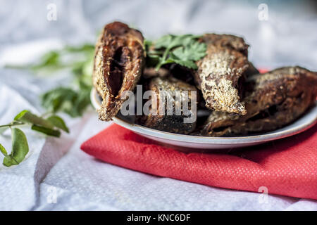 Les morceaux de poisson frit dans une plaque de verre avec des feuilles de cari. Banque D'Images