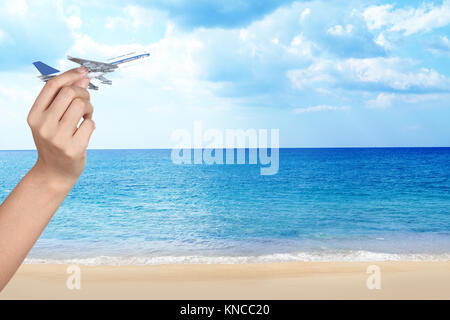 Hand holding toy airplane contre ciel, travel concept Banque D'Images