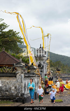 Femme avec des enfants portant des vêtements traditionnels balinais en face d'un temple local. Sengkidu village près de Candidasa, Karangasem Regency, Bali, Indon Banque D'Images