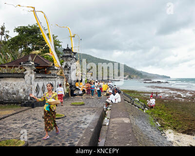 Femme portant des vêtements traditionnels balinais en face d'un temple local. Sengkidu village près de Candidasa, Karangasem Regency, Bali, Indonésie. Banque D'Images