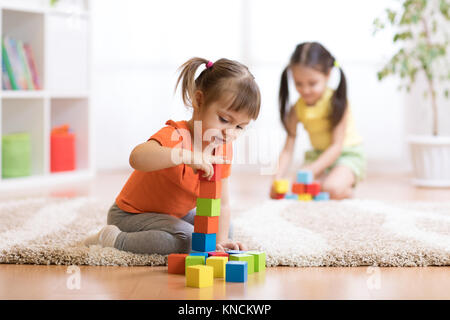 Les enfants jouant dans les jouets de bloc de jeux at nursery Banque D'Images