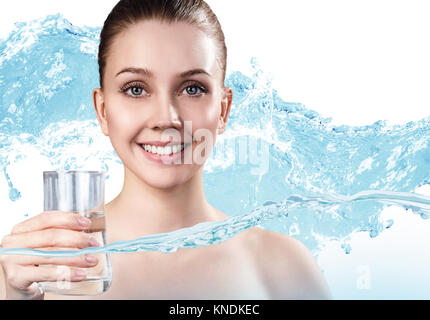 Jeune femme détient le verre avec de l'eau propre dans des éclaboussures d'eau. Banque D'Images