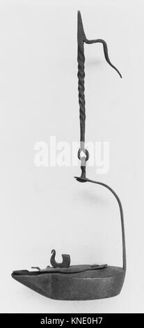 Lampe Betty de 1600 à 1700, en fer, servant de lampe à huile fonctionnelle avec porte-mèche et bec verseur, conservée comme artefact historique dans une collection de musée. Banque D'Images