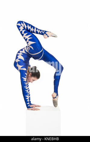 Acrobat n'gymnastique, droit isolé sur un fond blanc. Un jeune artiste de cirque dans un costume bleu , remplir d'éléments acrobatiques. Banque D'Images
