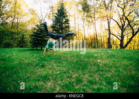 Garçon faisant la roue dans le jardin Banque D'Images