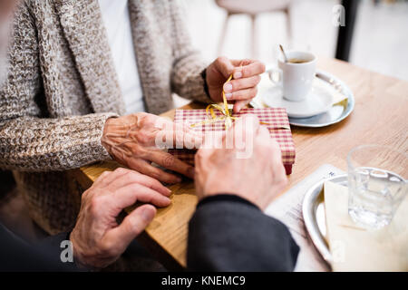 Couple avec un présent dans un café. Le temps de Noël. Banque D'Images