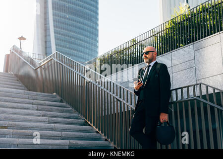 Businessman standing étapes, en utilisant smartphone, low angle view Banque D'Images