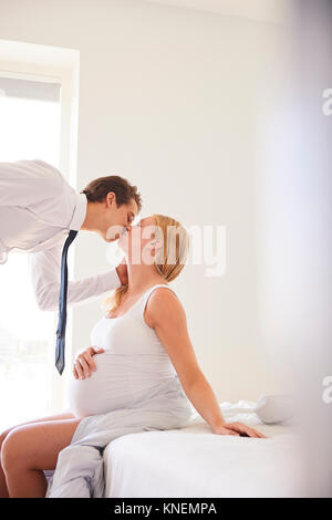 Pregnant woman kissing man mari dans la chambre Banque D'Images
