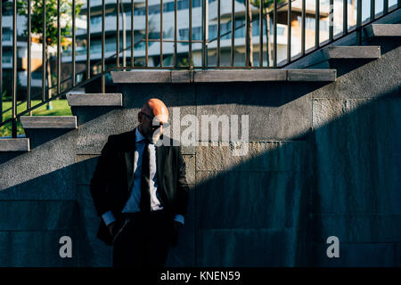 Portrait of businessman outdoors, debout à côté d'étapes, pensive expression Banque D'Images