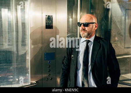 Businessman standing en ascenseur Banque D'Images
