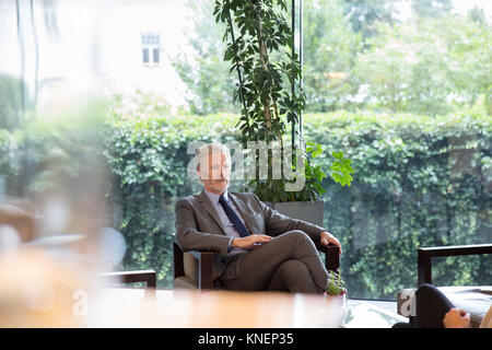 Businessman sitting in hotel lobby Banque D'Images
