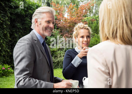 Smiling people à prendre des rafraîchissements au jardin Banque D'Images