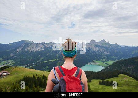 Vue arrière du female hiker avec vue sur vallée dans les montagnes de Tannheim, Tyrol, Autriche Banque D'Images