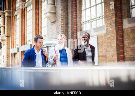 Trois hommes déjà à la gare, à marcher ensemble Banque D'Images