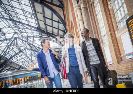 Trois hommes déjà à la gare, à marcher ensemble Banque D'Images