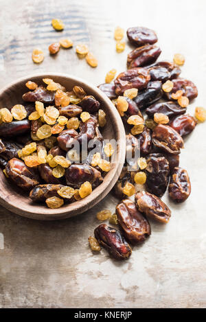 Dattes séchées et les raisins secs dans un bol jaune, close-up Banque D'Images