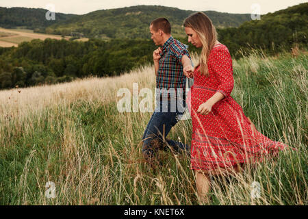 Enceinte Mid adult couple holding hands tout en flânant dans hillside Banque D'Images